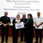 Datuk Norliza Abdul Rahim (dua dari kiri) menyerahkan sumbangan Bantuan Pengajian KPT-PTPTN Prihatin kepada seorang pelajar di UUM. - Foto PTPTN